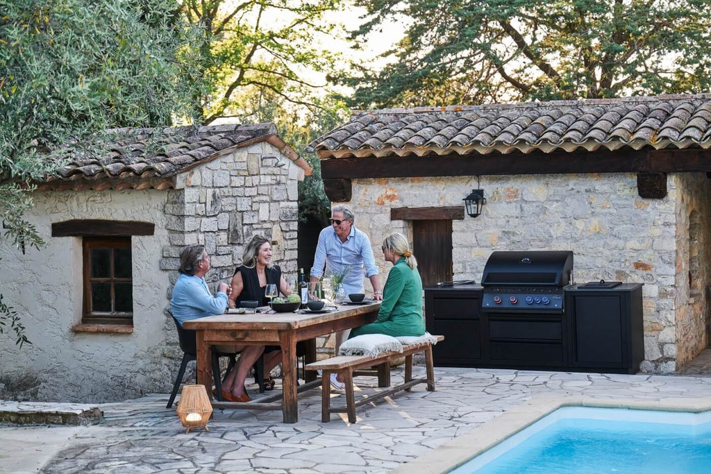 Napoleon OASIS outdoor kitchen in a garden with people
